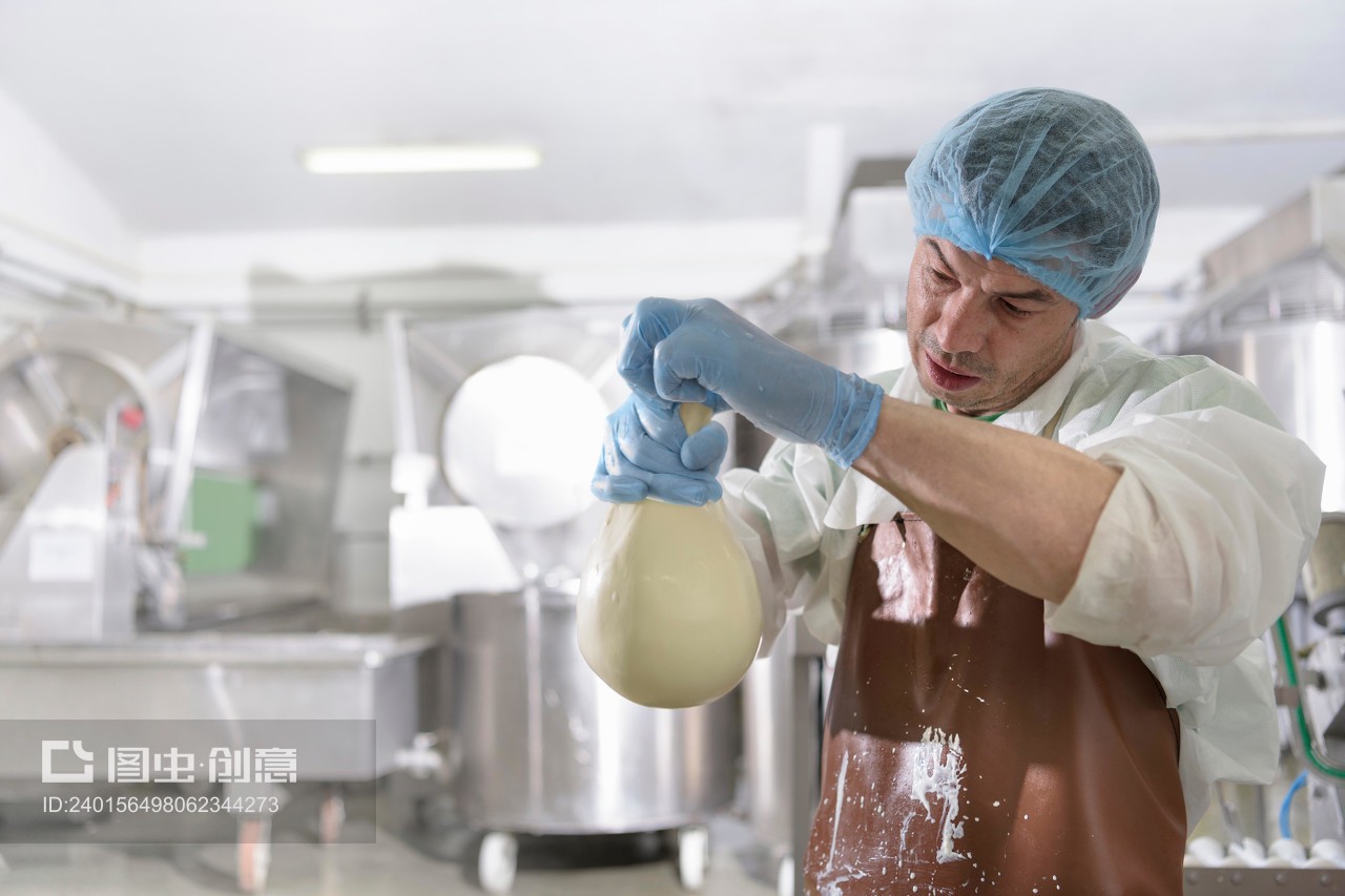 Worker hand making mozzarella ball in cheese factory